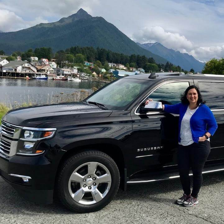 Black Suburban with Mount Verstovia and Sitka channel in the background. 